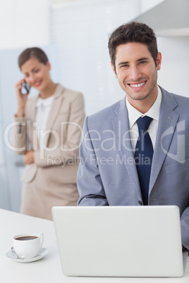 Happy businessman using a laptop before going to work