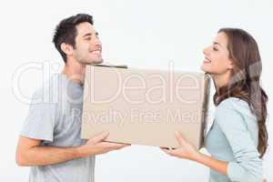 Cheerful woman and her husband holding a box