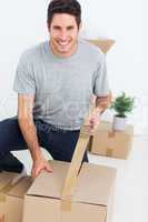 Cheerful man wrapping a box