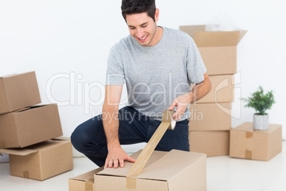 Happy man wrapping a box