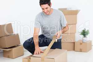 Happy man wrapping a box