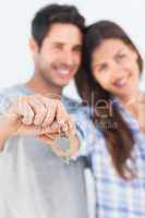 Man and wife presenting a key with a house keychain