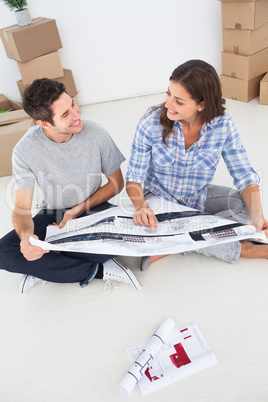 Happy woman and her husband looking at their house plans