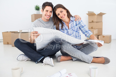 Portrait of man and woman holding house plans