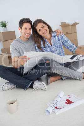Portrait of man and his wife holding house plans