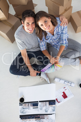 Overview of a man and his wife holding house plans