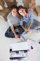 Overview of a man and his wife holding house plans