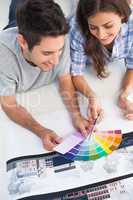 Couple looking at a color chart to decorate their house