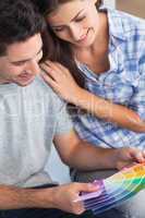 Couple looking at color samples to decorate their house
