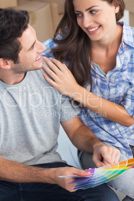 Happy couple looking at color samples to decorate their house