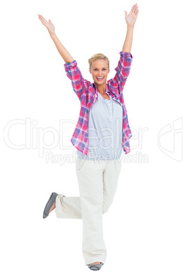 Excited woman standing with hands and foot up in air