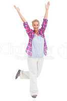 Excited woman standing with hands and foot up in air