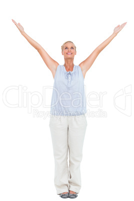 Blonde woman standing with hands up in air