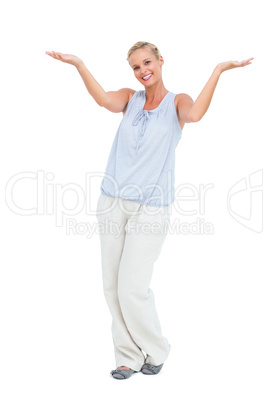 Blonde woman with arms raised smiling at camera