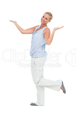 Happy woman standing with hands up and leg raised