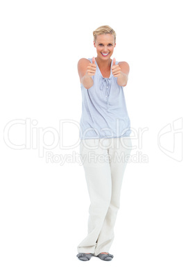 Happy woman standing with thumbs up smiling at camera