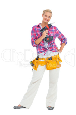 Happy woman standing holding a drill