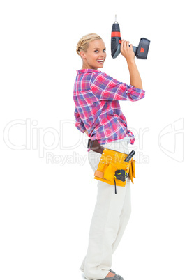 Blonde woman standing holding a drill