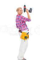 Blonde woman standing holding a drill