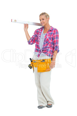 Blonde woman standing while holding a spirit level