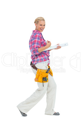 Blonde woman standing while playing with a spirit level
