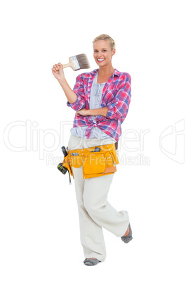 Blonde standing while holding a paint brush