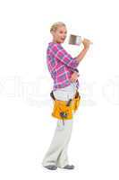 Blonde holding paint brush wearing a tool belt