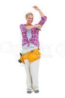 Woman holding paint brush wearing a tool belt