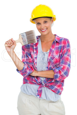 Attractive handy woman holding a brush and smiling at camera