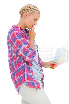 Concentrated young woman looking at color charts