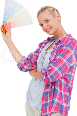 Young woman holding color charts and smiling at camera