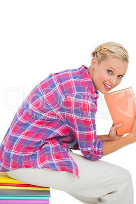 Beautiful young woman holding a book and sitting