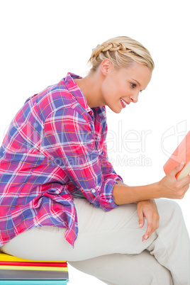 Smiling woman sitting on a stack of books