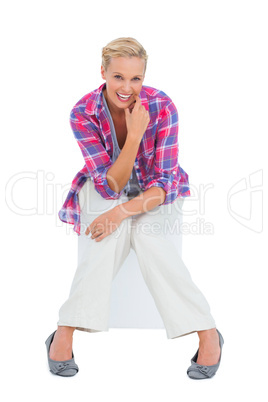 Attractive young woman sitting and smiling at camera