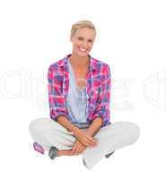 Beautiful blonde sitting on the floor and smiling at camera
