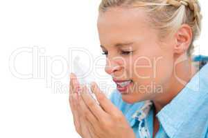 Ill woman sneezing into tissue