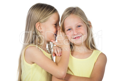Blonde girl whispering to her sister