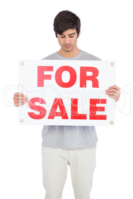 Man looking at a for sale board