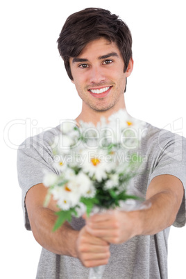 Young man offering a flower bouquet