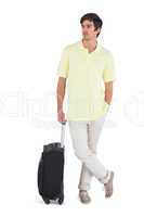Thoughtful man standing with his suitcase
