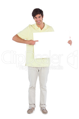 Smiling man pointing something on empty sign