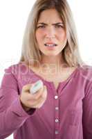 Irritated woman using remote control