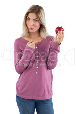 Blonde woman pointing to apple with her finger