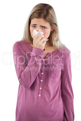 Woman blowing her nose while looking at the camera