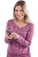 Smiling woman sending text message