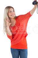 Woman making peace sign while taking a picture of herself