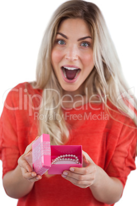 Surprised woman discovering necklace on a box