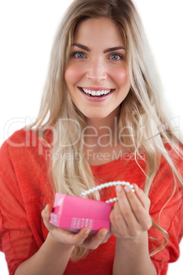 Cheerful woman discovering necklace in a gift box