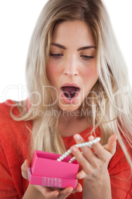 Shocked woman discovering necklace in a gift box