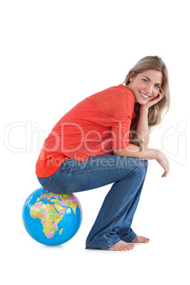Smiling woman sitting on a globe